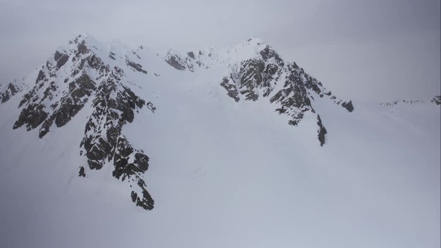 Aerial view of a snow covered mountain on a cloudy day