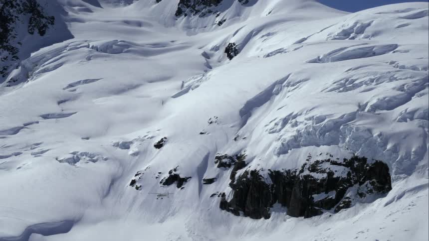 Airplane flies over glacial mountain terrain