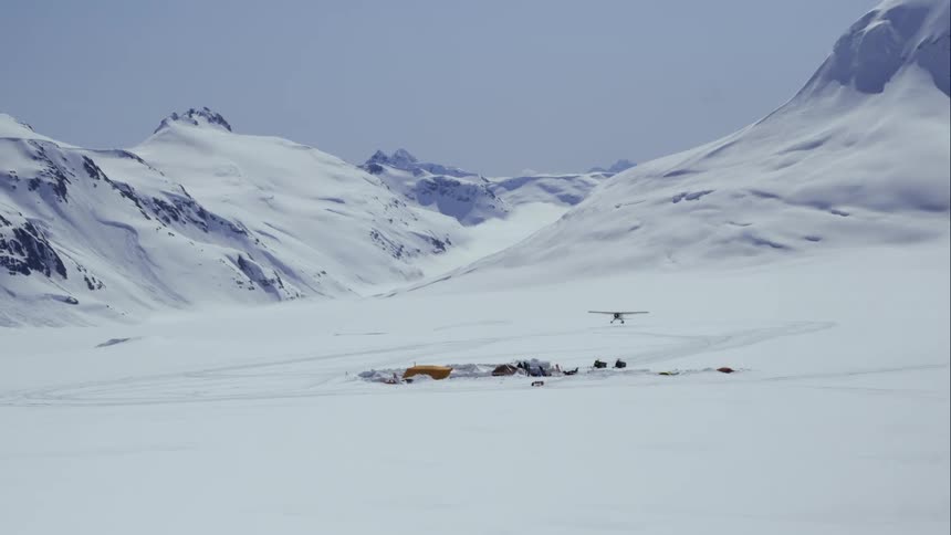 Small airplane makes landing near base camp in snowy mountains