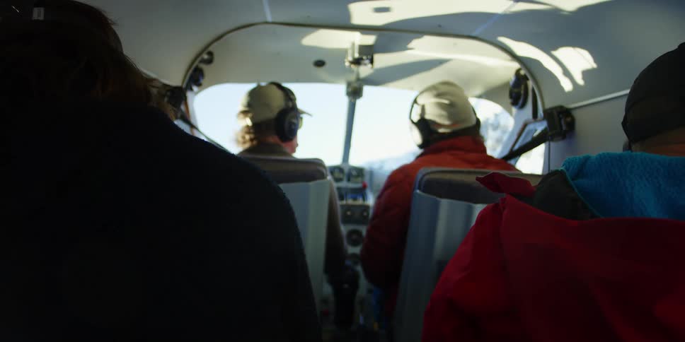 Passengers look out windows as pilot flies plane