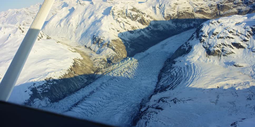 The plane flies over the mountains