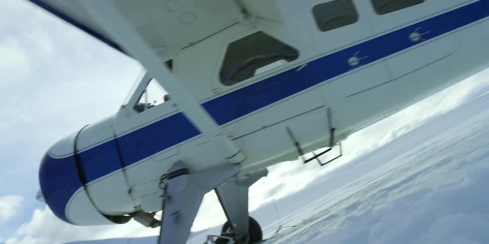 A small airplane begins to move across a snowy field in preparation for take off