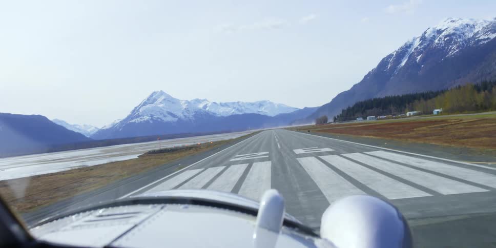 An aircraft lands on a rural mountainside runway