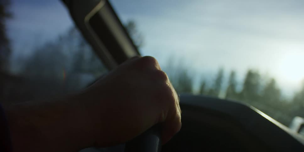 Close up of a mans hand while he drives his car