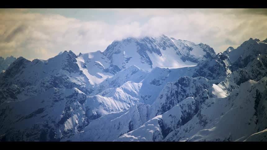 Time lapse of clouds rolling over the snow covered peaks of a mountain range