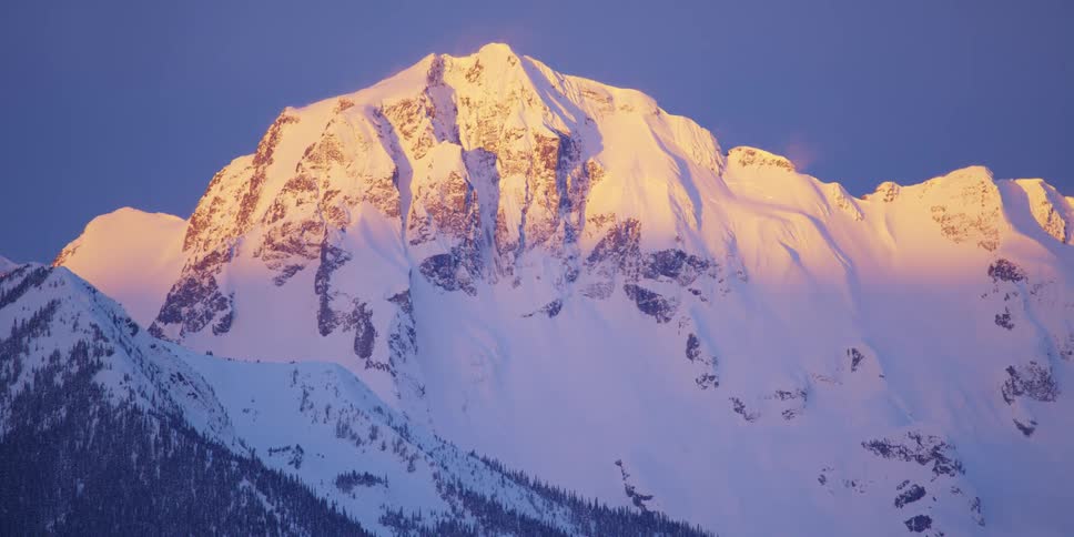 An aerial view of a mountain at dusk is displayed