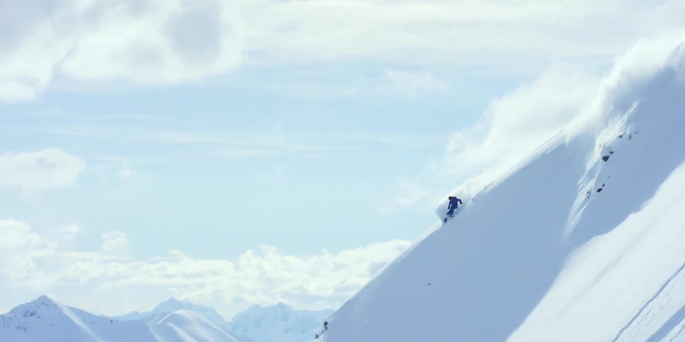 Person skis down mountain slope
