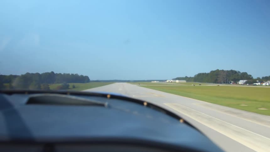 Small airplane landing on tarmac at rural airfield