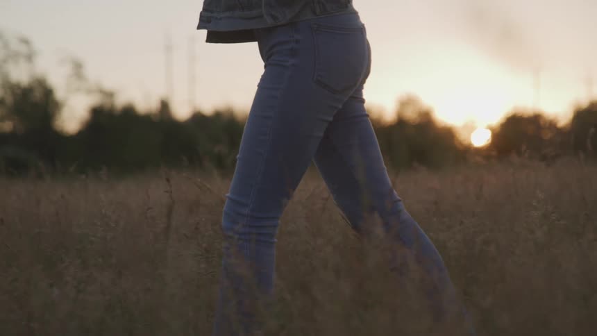 A woman is walking outdoors at dusk
