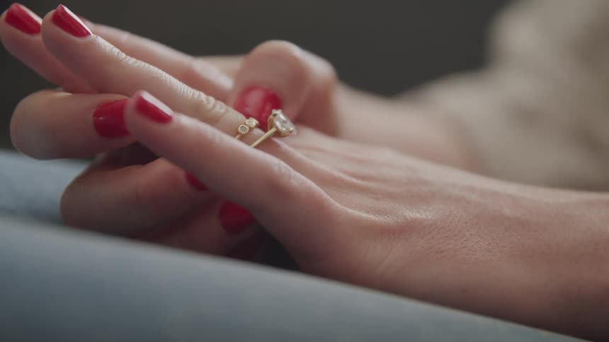 A woman turns her wedding band on her finger