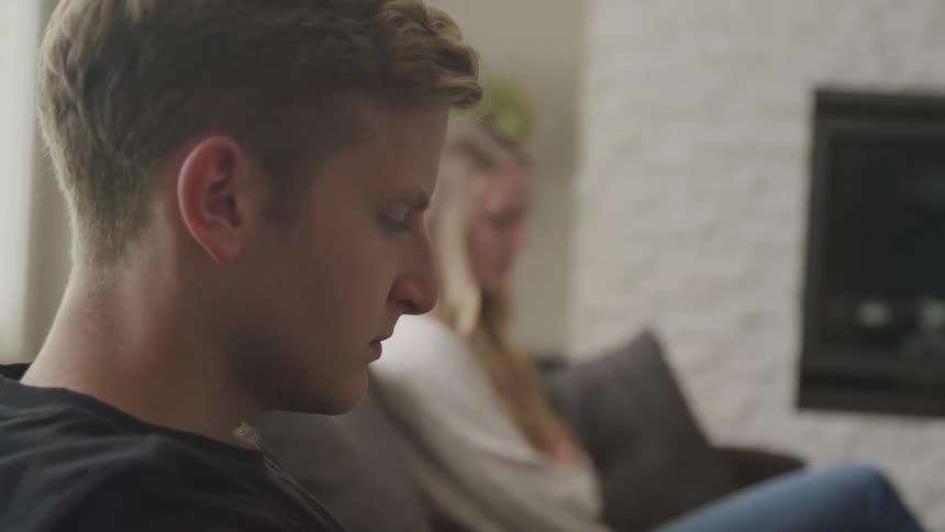 A man and a woman sitting on a couch in a room