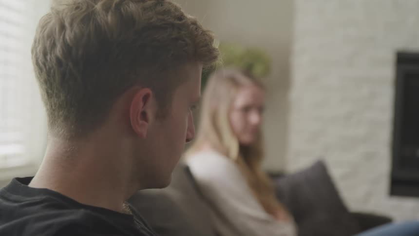 A man and woman are sitting on a couch