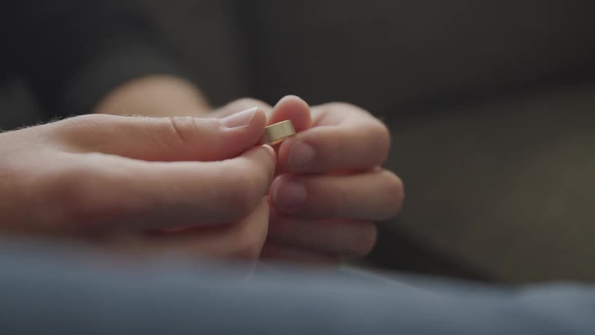 A man is holding his wedding ring