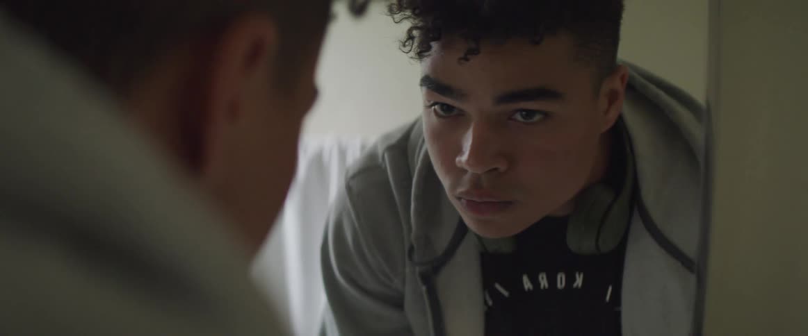 A man looking at himself in the mirror while washing hands
