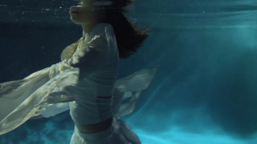 A fully clothed teenage girl under water