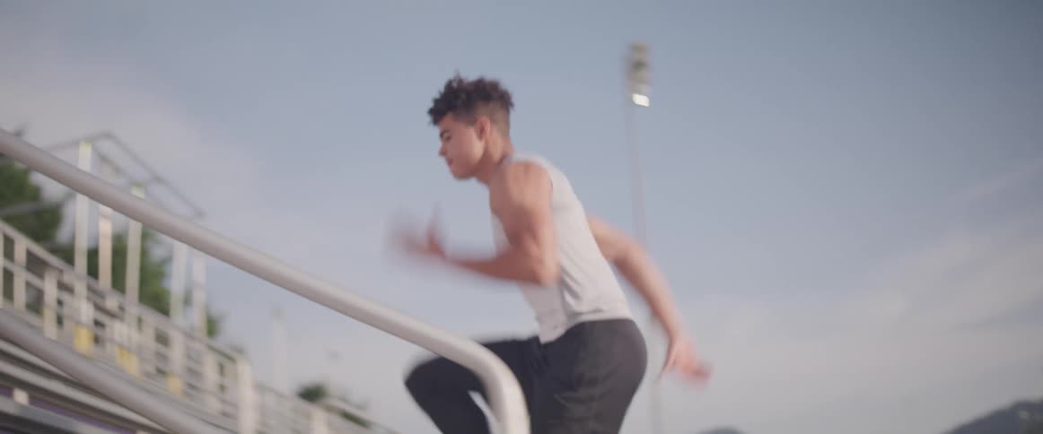 Young man running up bleachers