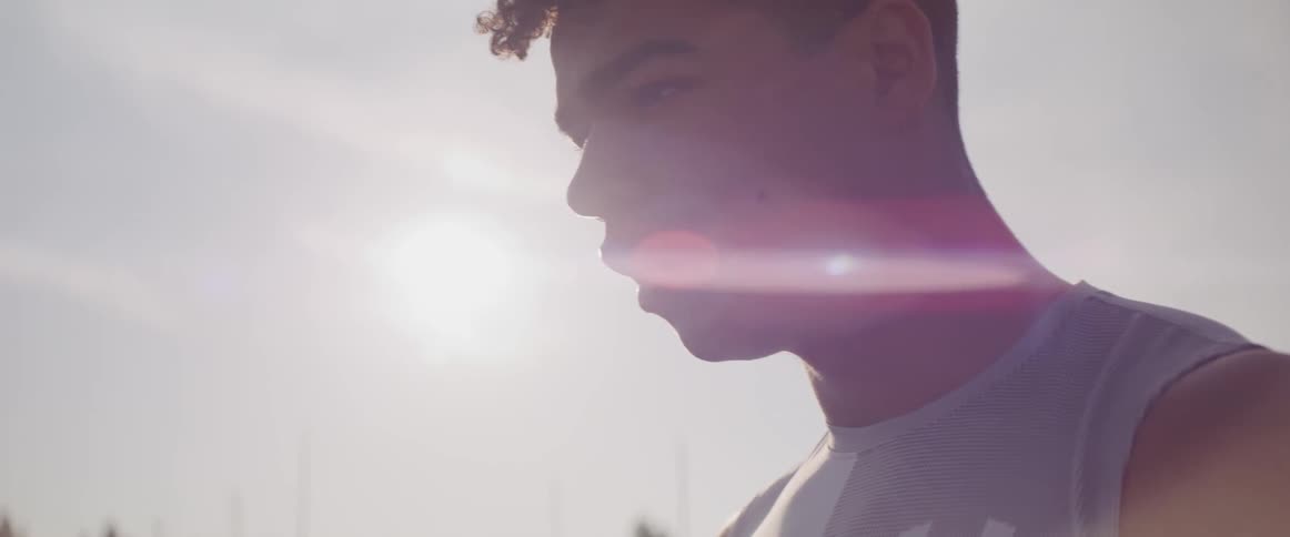 A teenage boy outside breathes heavy after exercising