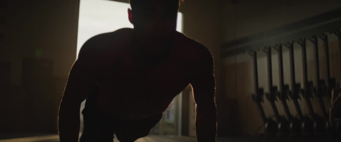 Young man doing pushups in empty gym