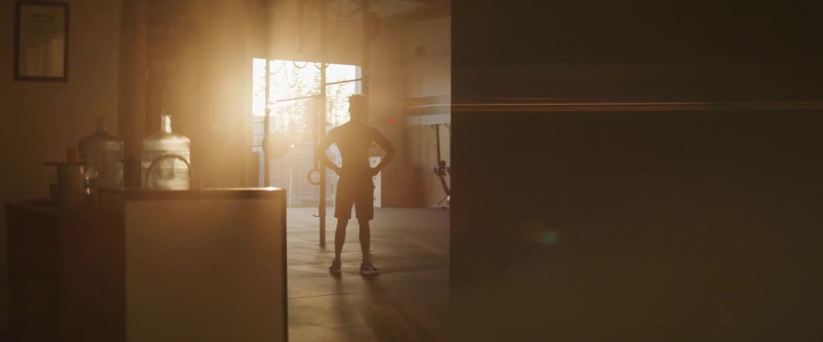 A silhouette of a man standing with a doorway and sunlight in the background