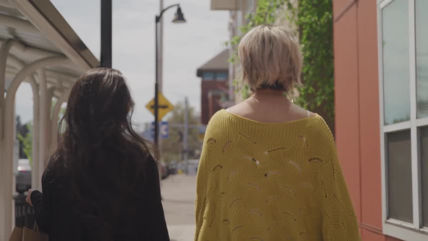 Two women are walking in a downtown city