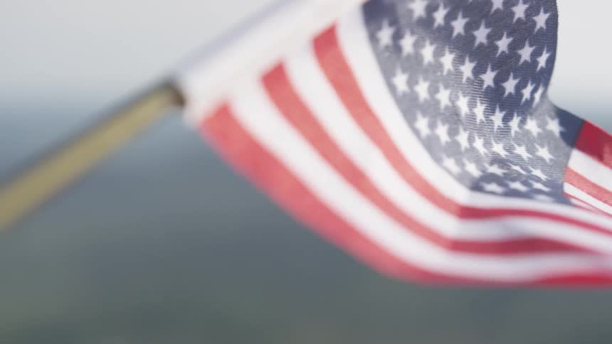 A small american flag waves in the wind