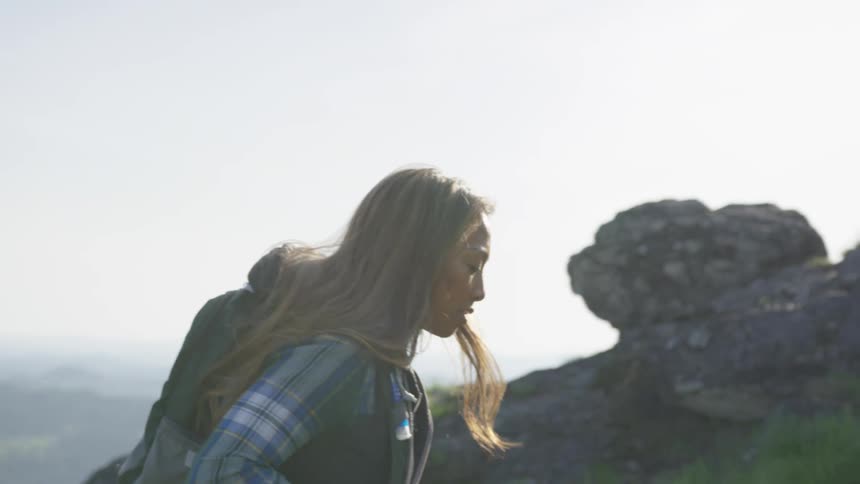 Two women are hiking up a hill