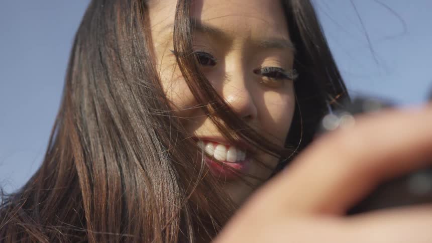 Woman holding camera smiling