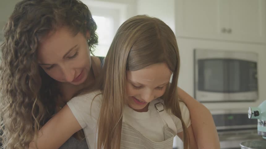 A mother and daughter cooking together in the kitchen