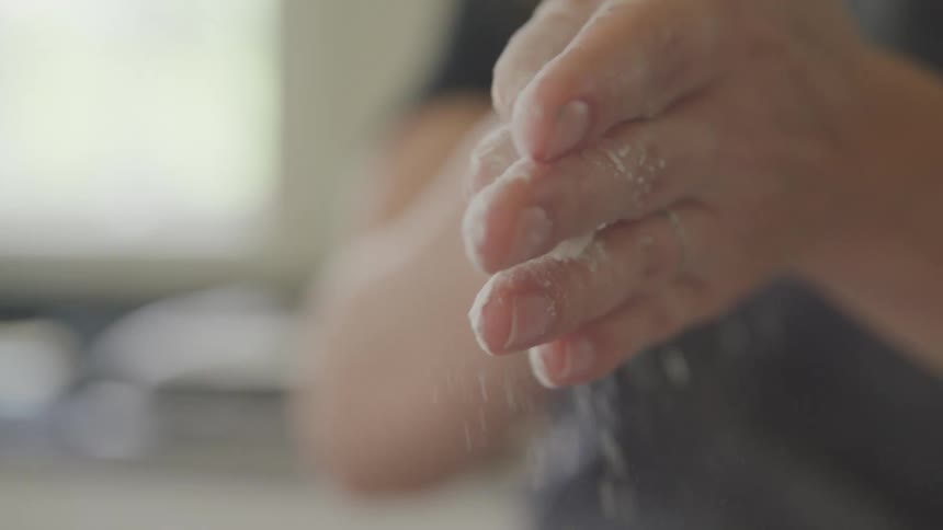 Flour covered hands rubbing together