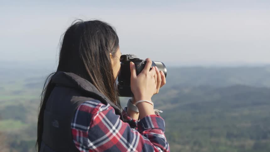 A young woman takes pictures of the landscape