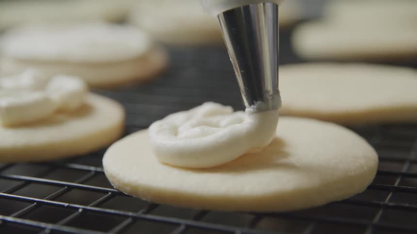 Icing being piped on to a cookie