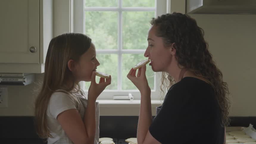 Mother and daughter enjoying homemade cookies in the kitchen