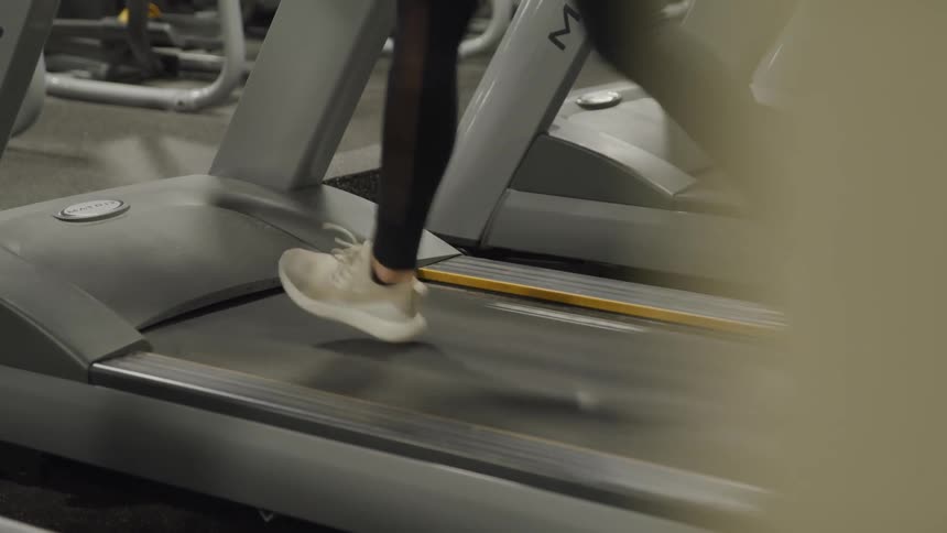 A woman running on a treadmill in a gym