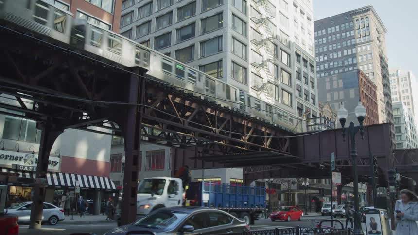 A downtown city area full of people cars and the subway