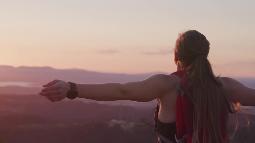 A woman is standing outdoors at dusk