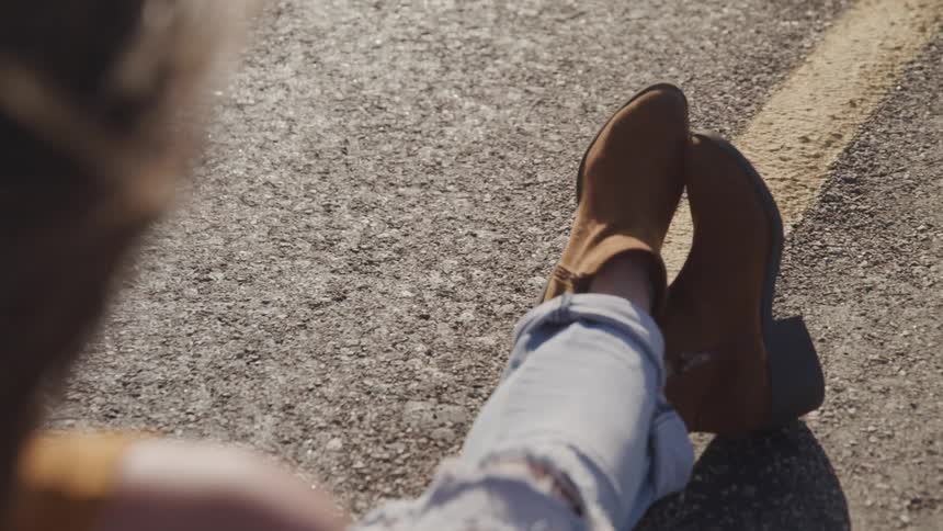 A person sitting outside wearing boots