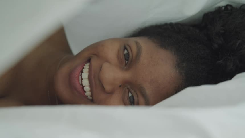 A woman is laying down on a bed