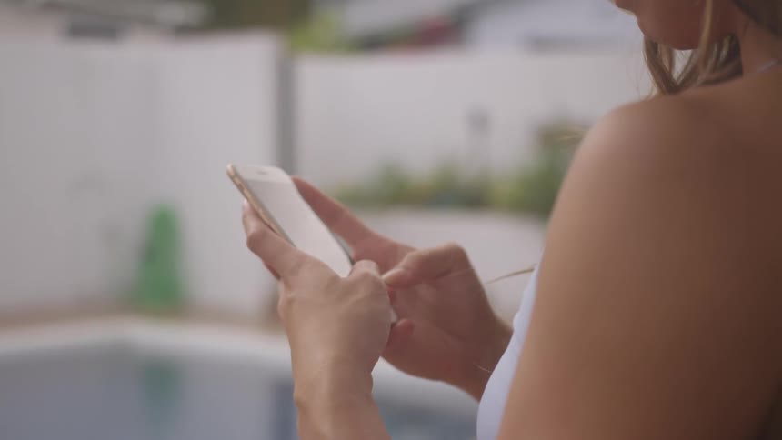 A woman texting on her cell phone outside