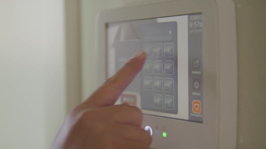A person using their finger to key in a security alarm code