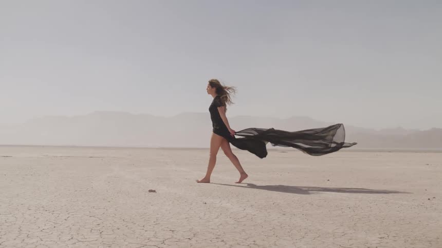 A woman is walking through a desert
