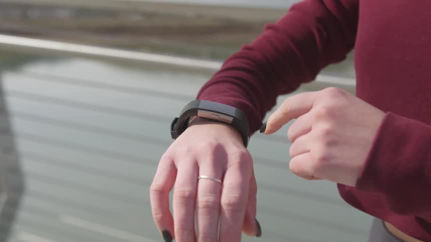 A woman scrolls through her smart watch