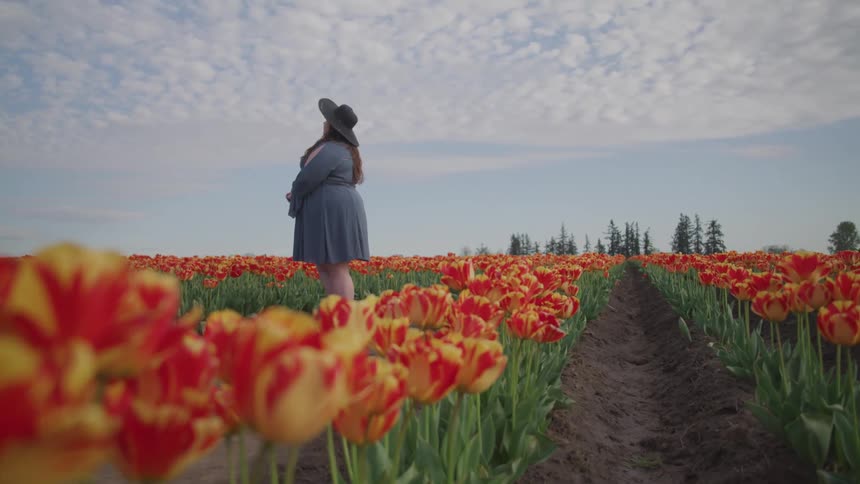 A woman is standing in a flower meadow