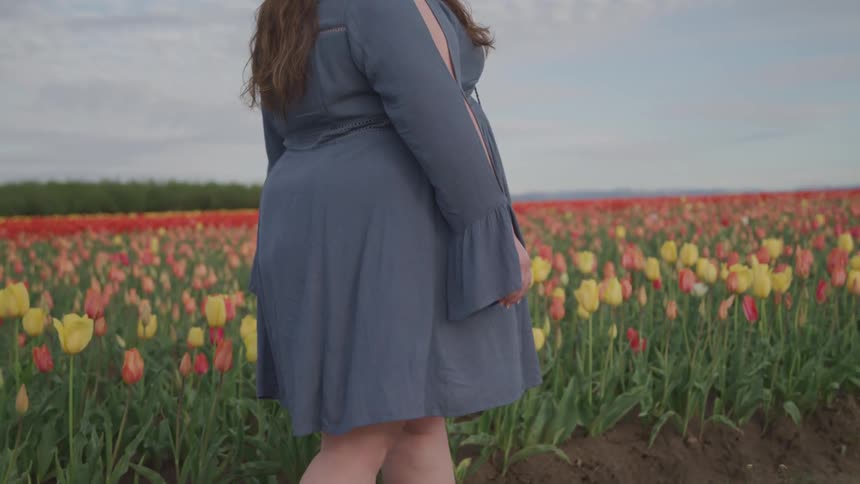 A woman walks next to a field of flowers
