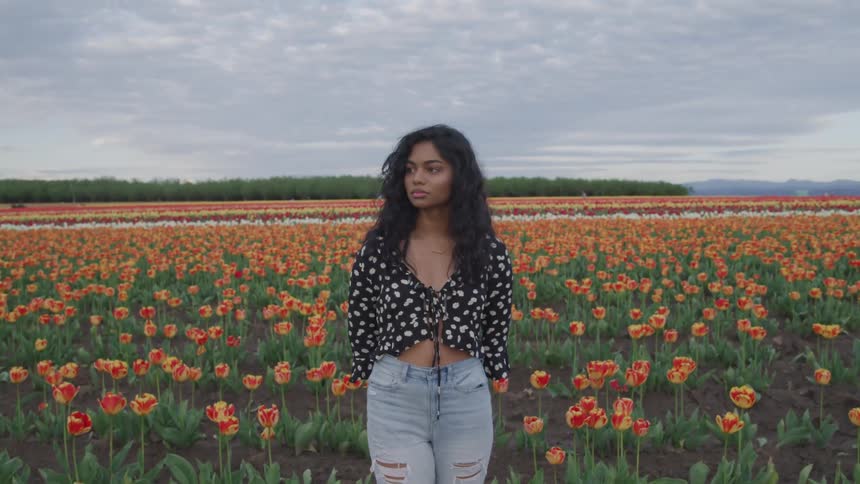 A woman is standing in a flower meadow