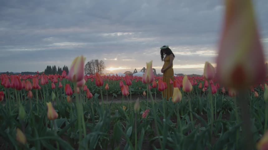 A young woman standing in a field of flowers