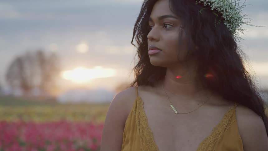 A woman is standing outdoors at dusk