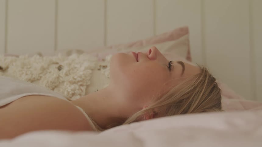 Woman lies down on bed