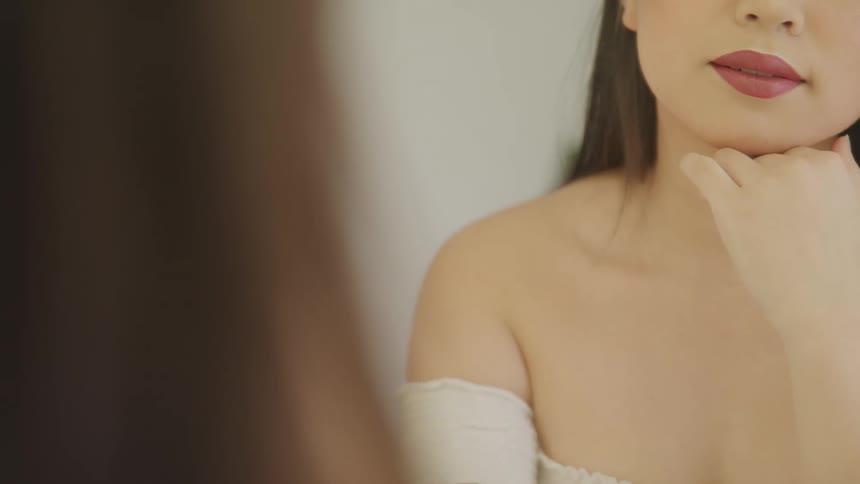 A woman is looking at herself in the mirror