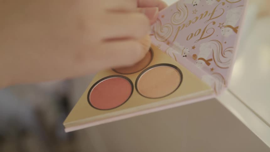A woman is putting on makeup