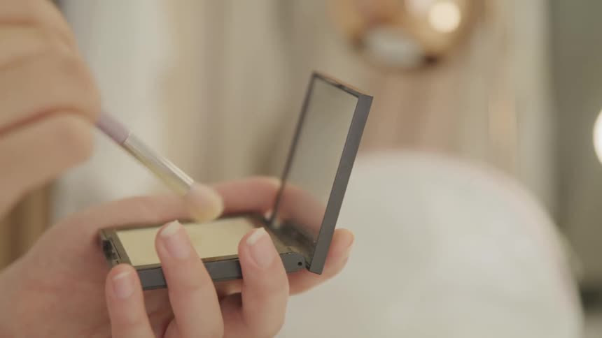 A person using a brush to apply makeup